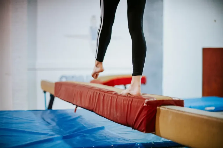 Young gymnast balancing on a balance beam